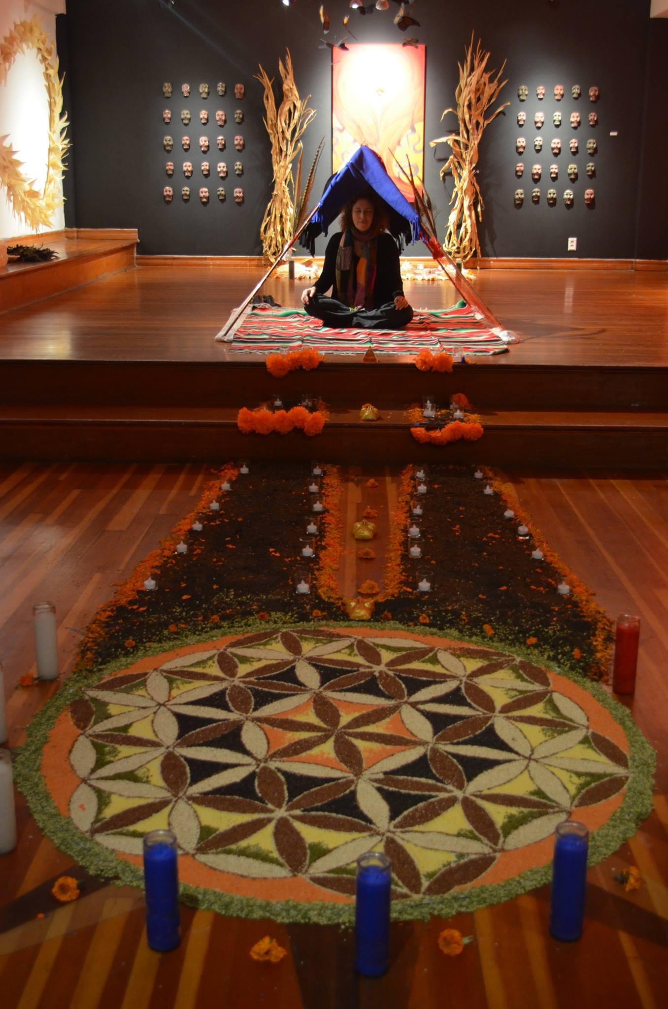 Woman meditating within a Day of the Dead Installation